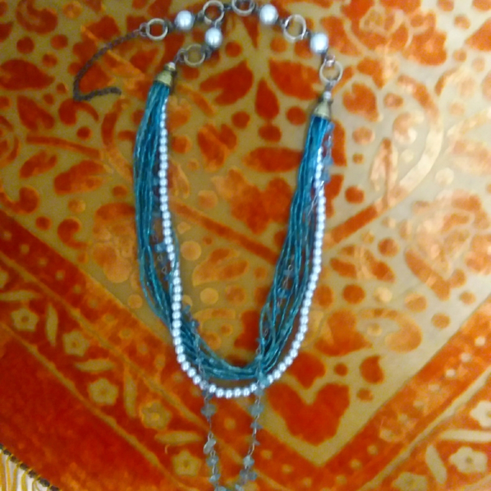 Multi strand beads in teal with pearls.